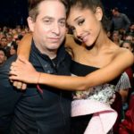 Man hugging a smiling woman at an awards show