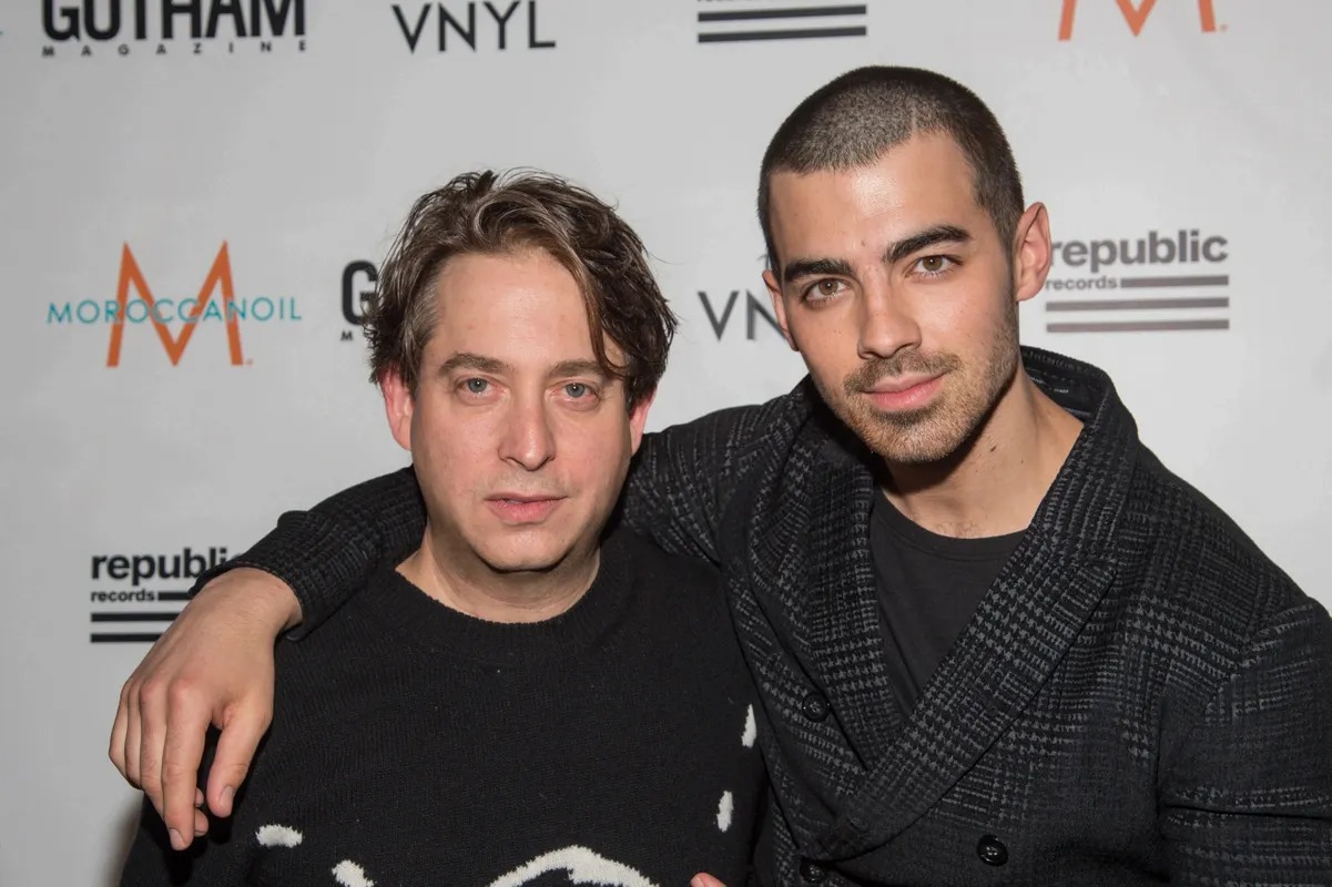 Two men posing with arms around each other at a music event