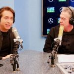 Two men in headphones at a radio studio microphone