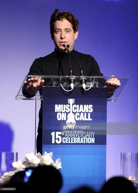 Man speaking at a podium at a Musicians On Call celebration