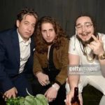 Three men posing together on a lounge sofa
