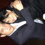 Two men embracing playfully at a party