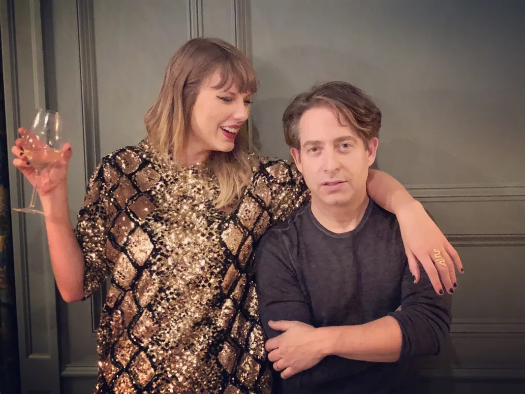 Woman with a wine glass and her arm around a man at a party