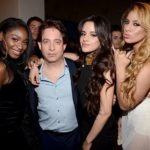Man posing with three women at an industry event