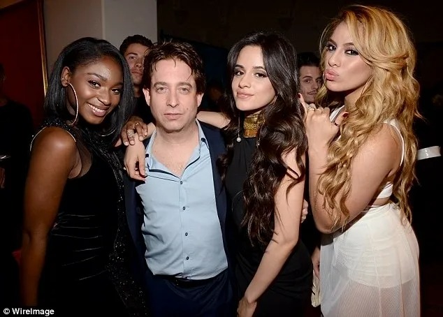 Man posing with three women at an industry event