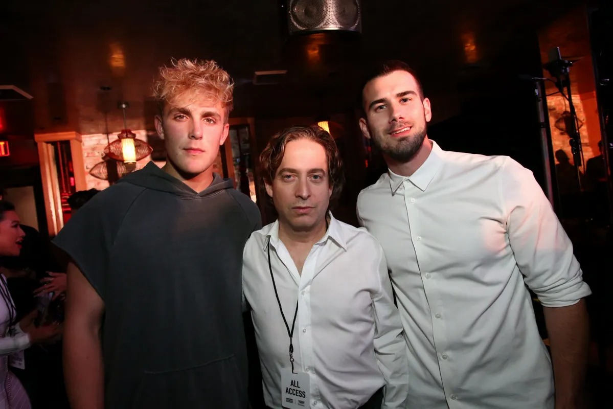 Three men posing together at a dimly lit party