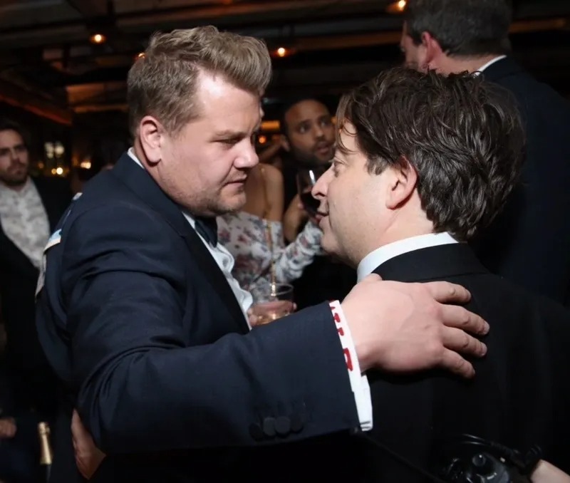 Two men greeting each other with a hug at a party
