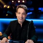 Smiling man seated at a lit judges desk
