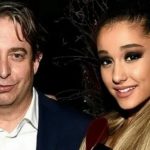 Man in a suit posing with a smiling woman with long hair