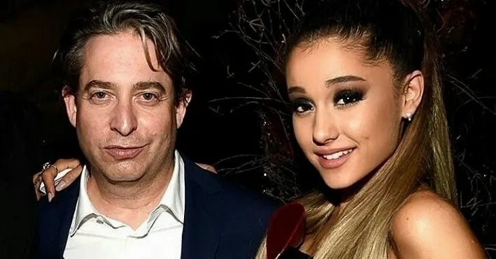 Man in a suit posing with a smiling woman with long hair