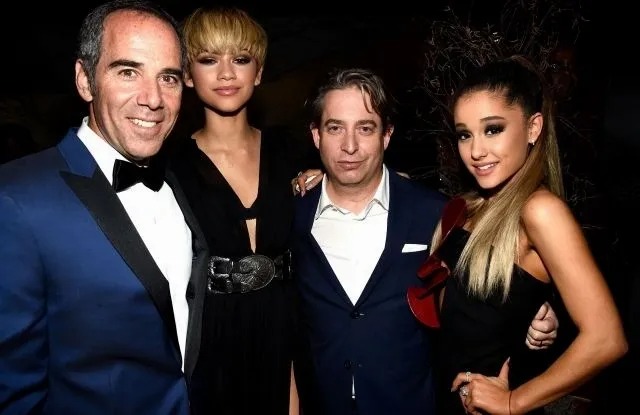 Two men posing with two women at a formal event