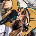 Selfie of a man in sunglasses in front of a street mural
