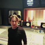 Man standing at a mixing console in a recording studio