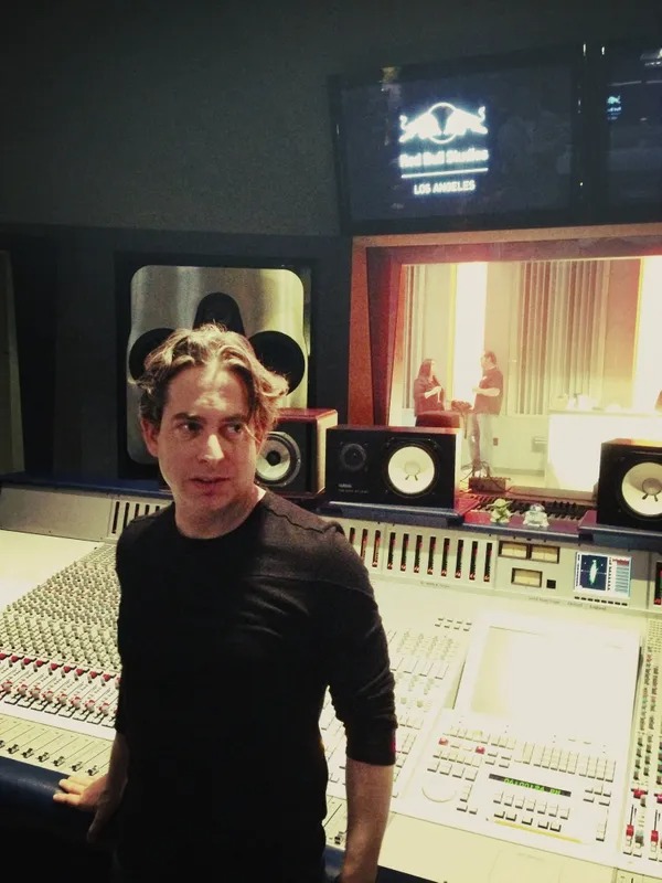 Man standing at a mixing console in a recording studio