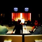 Producers working at a large studio mixing desk