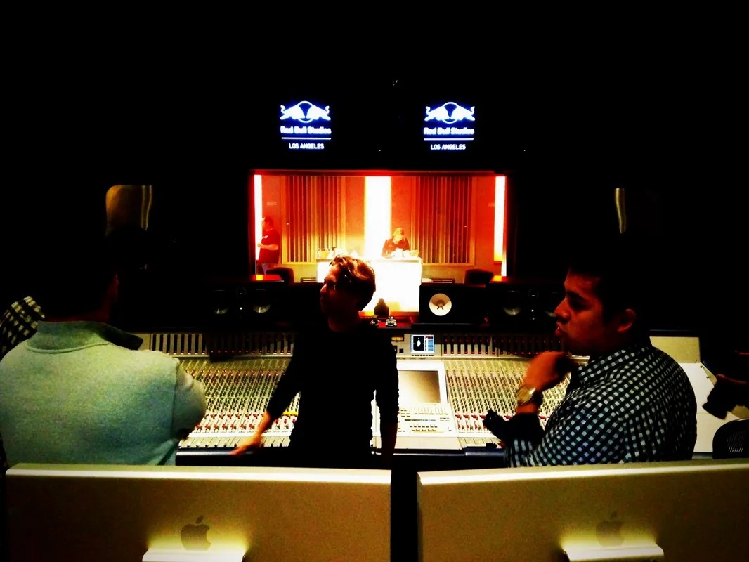 Producers working at a large studio mixing desk