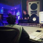 Recording studio with mixing board and large monitors