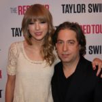 Man and woman posing at a concert tour press backdrop