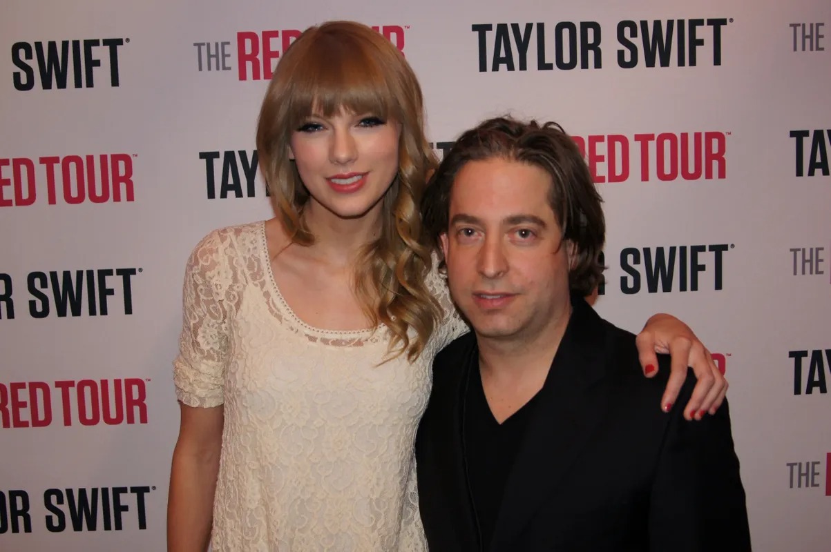 Man and woman posing at a concert tour press backdrop