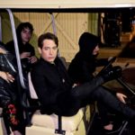 Group of friends sitting in a golf cart at night