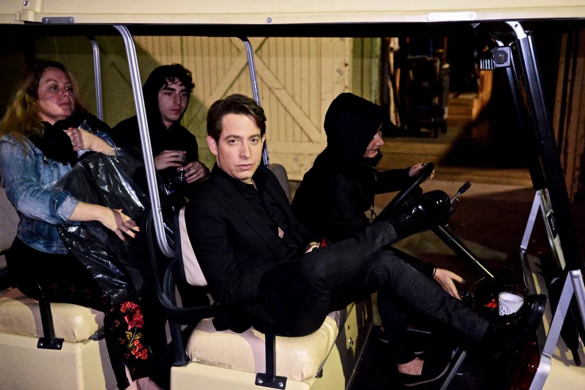 Group of friends sitting in a golf cart at night
