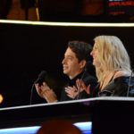 Two judges watching intently from a dark desk