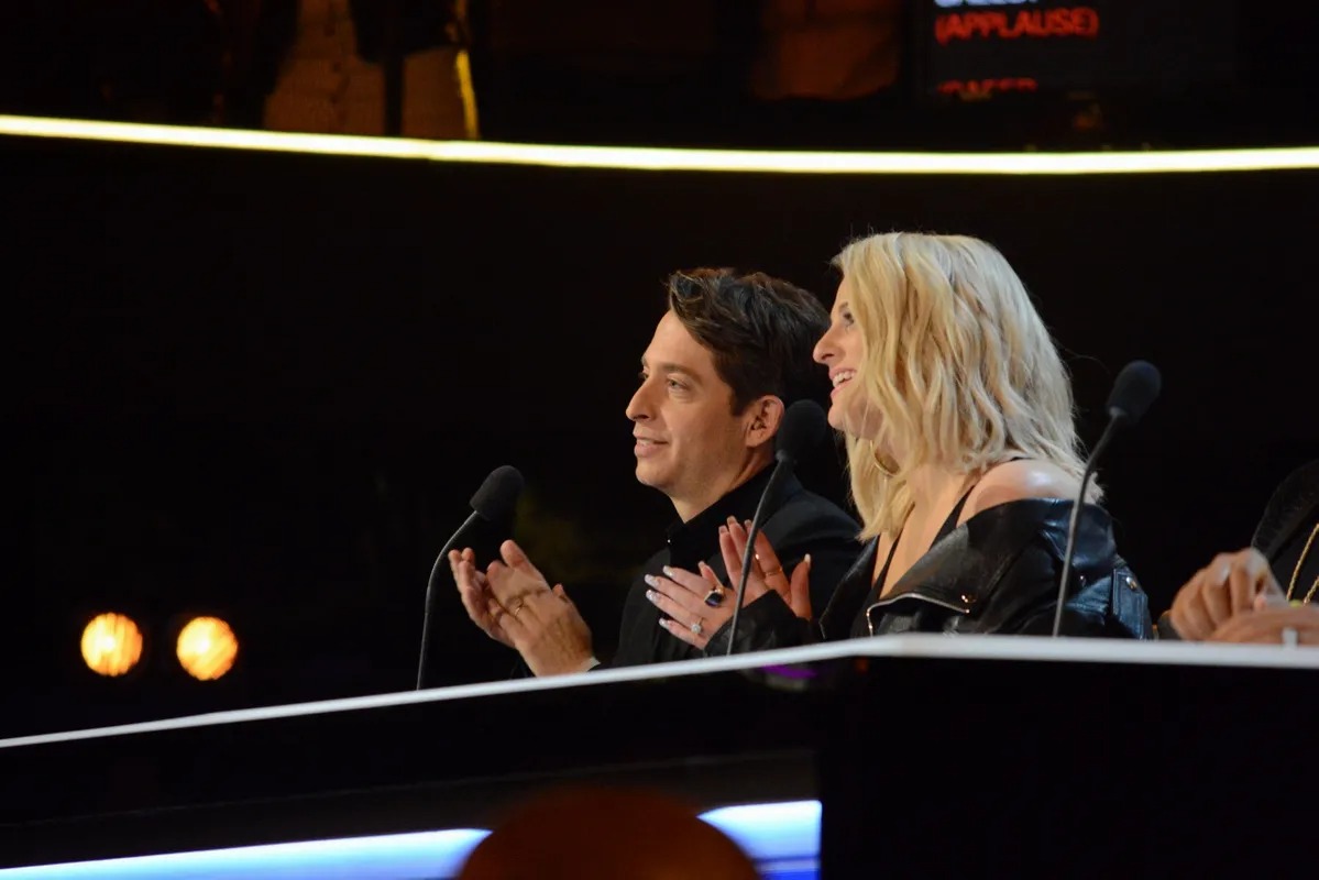 Two judges watching intently from a dark desk