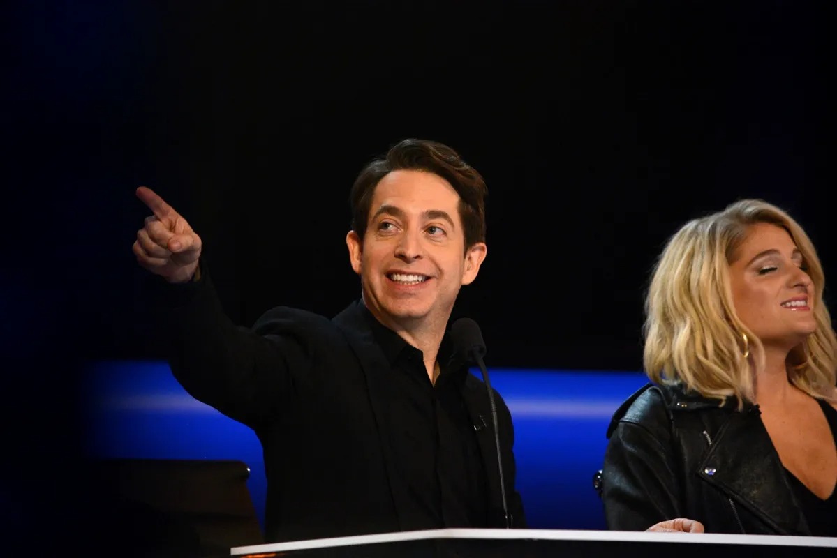 Judge pointing out toward the audience from the desk