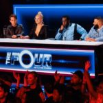 The Four judges desk with fans raising their hands