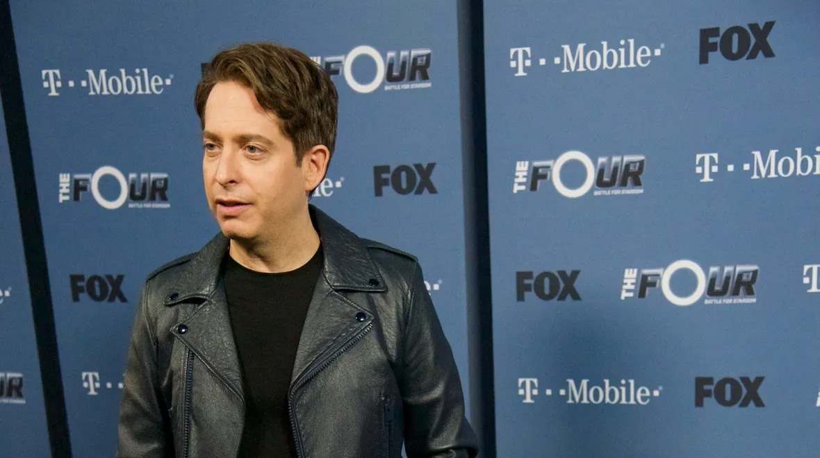 Man in a leather jacket at a Fox and T-Mobile press wall