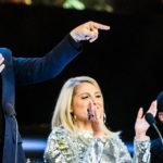 Man pointing from the stage as judges watch