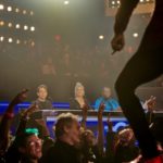 Performer jumping above a cheering live audience
