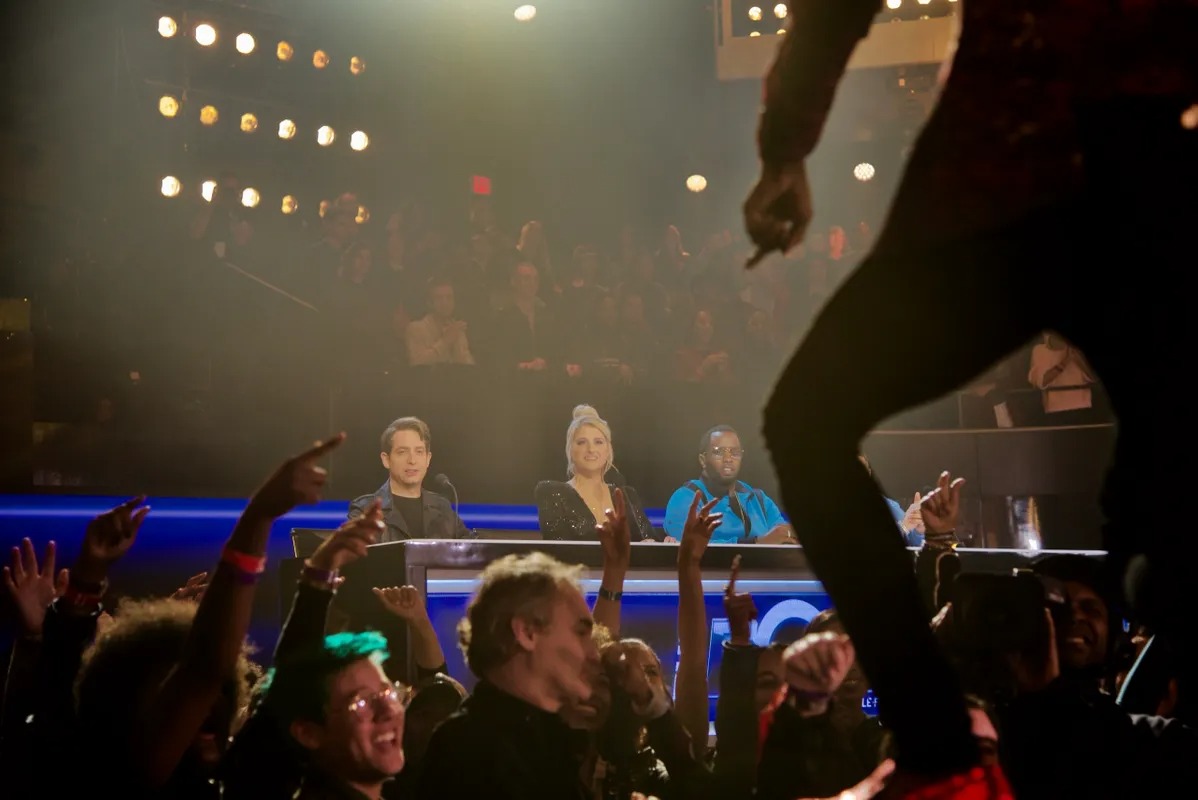 Performer jumping above a cheering live audience