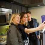 Three women taking a selfie in a backstage kitchen