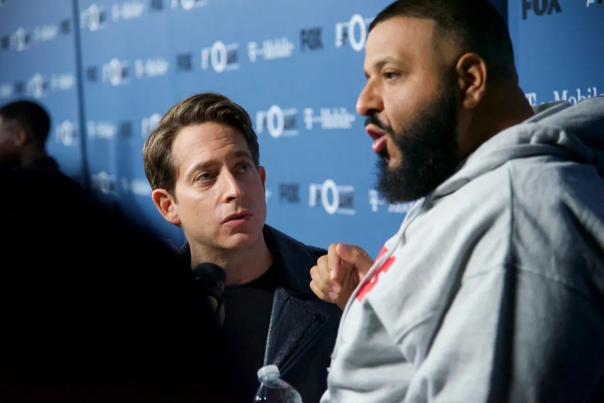 Two men talking face to face at a press event