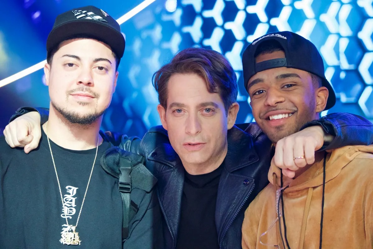 Three men posing close together at a concert event