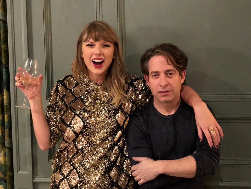 Woman in a sequin dress raising a glass beside a man