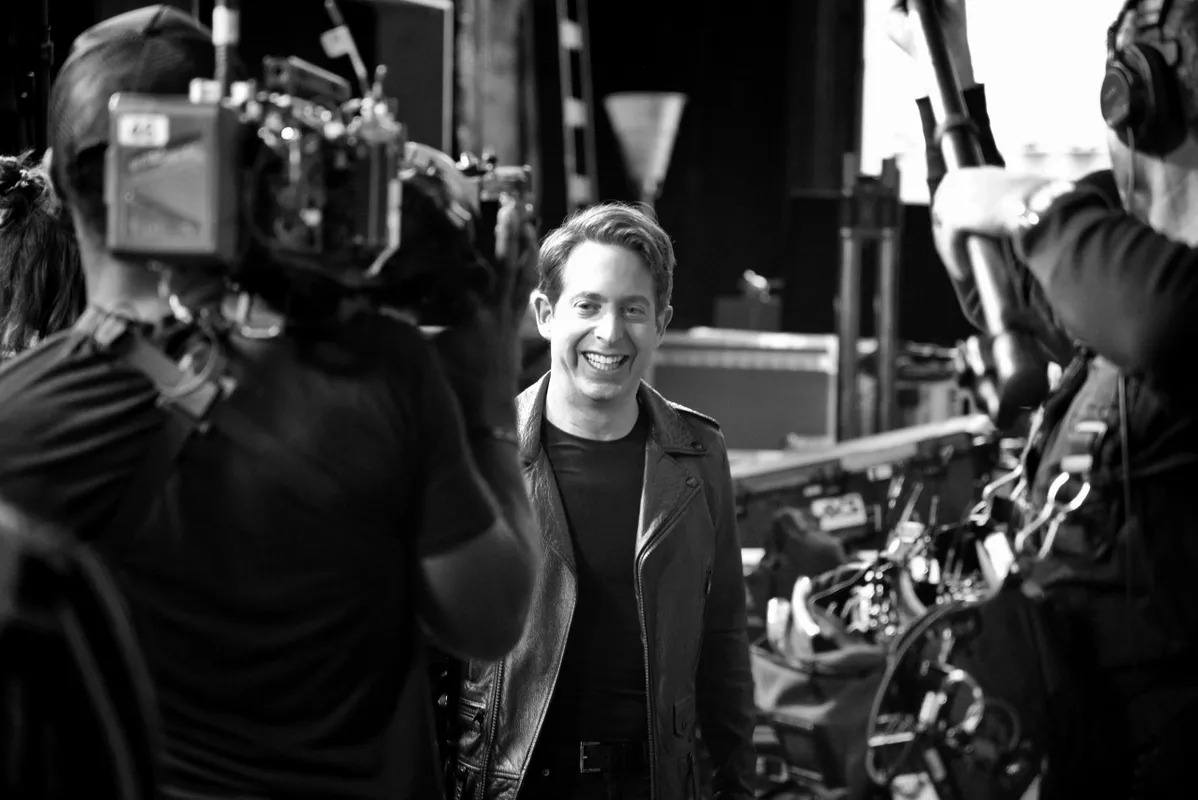 Black and white photo of a camera operator filming a man on set