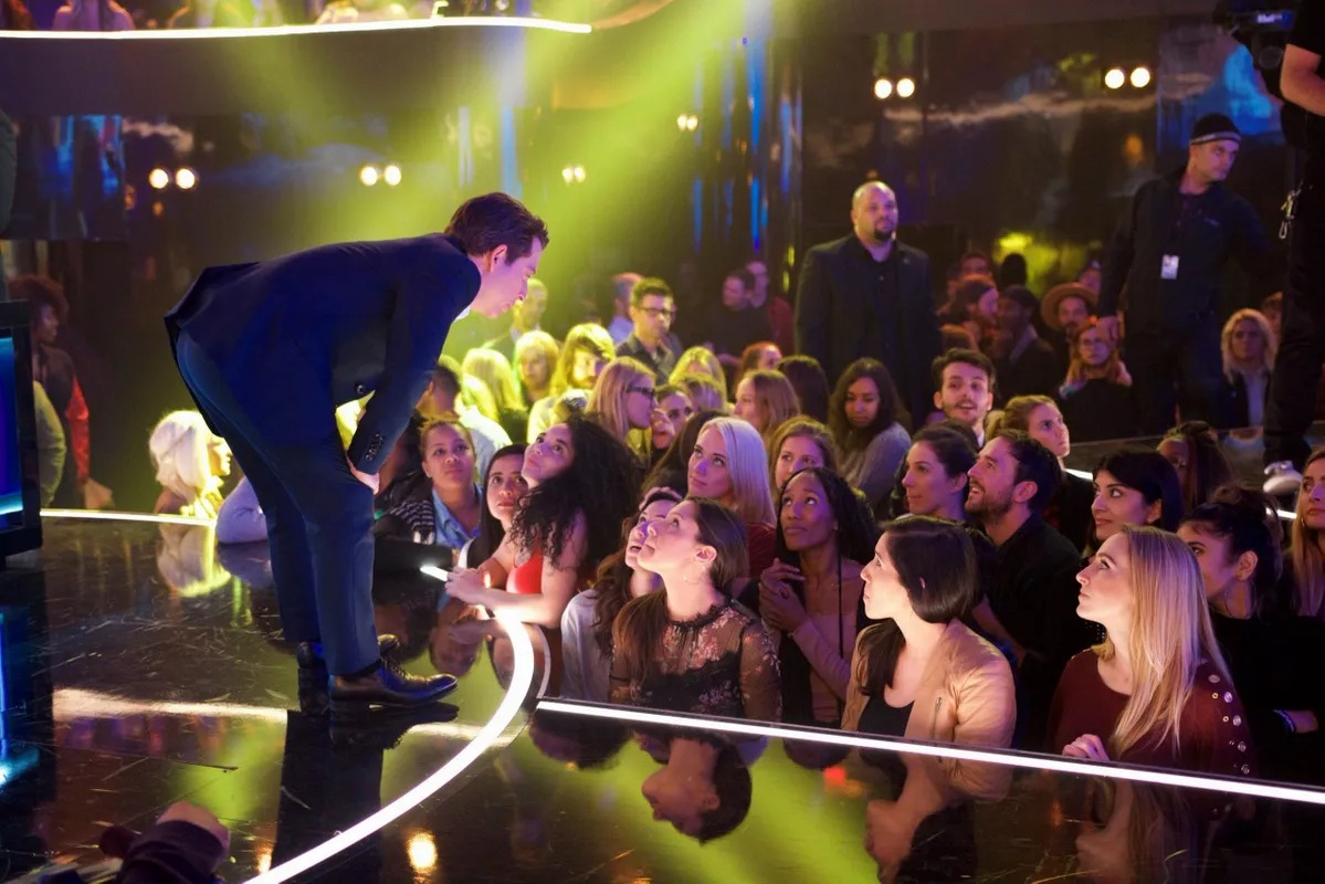 Man leaning over the stage edge toward the crowd