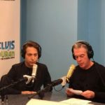 Two men in headphones recording a radio show
