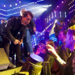 Performer leaning toward a cheering crowd at a live show