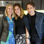 Three people posing together in a backstage kitchen