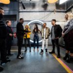 Group of performers and crew gathered in a studio corridor