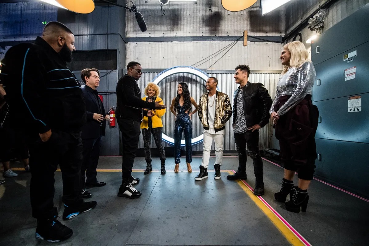 Group of performers and crew gathered in a studio corridor