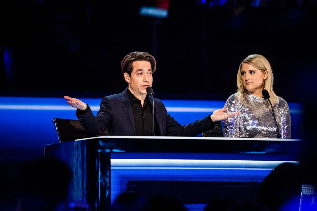Two judges talking at a blue-lit desk
