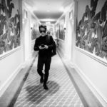 Man walking down a hallway with graffiti-style walls