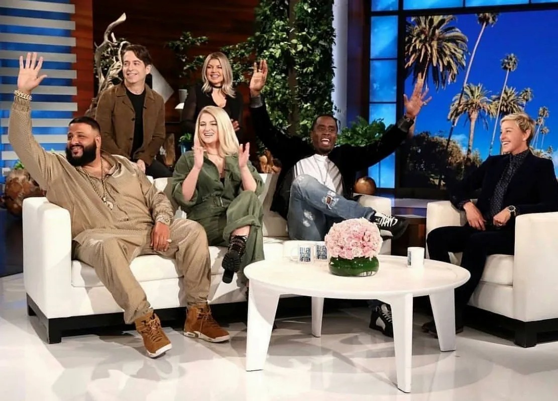 Guests waving from the couches of a television talk show set