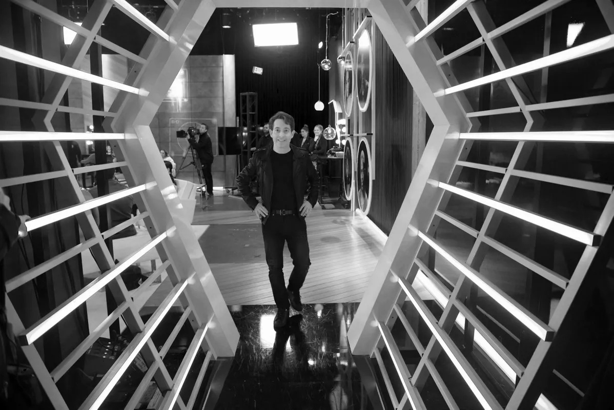 Man walking through a white hexagon-lit tunnel