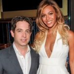 Man in a gray suit and woman in white posing indoors