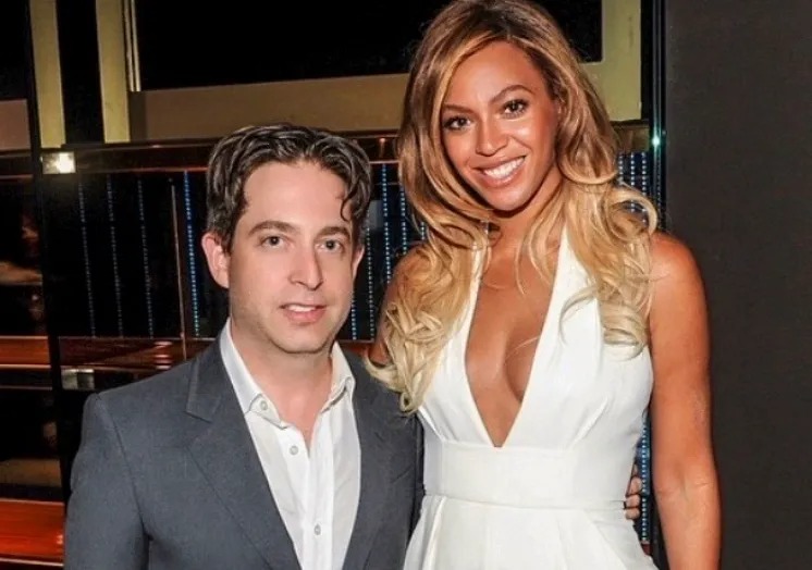 Man in a gray suit and woman in white posing indoors